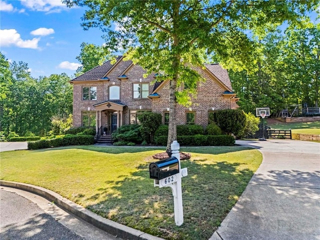 view of front of home featuring a front lawn, brick siding, and driveway