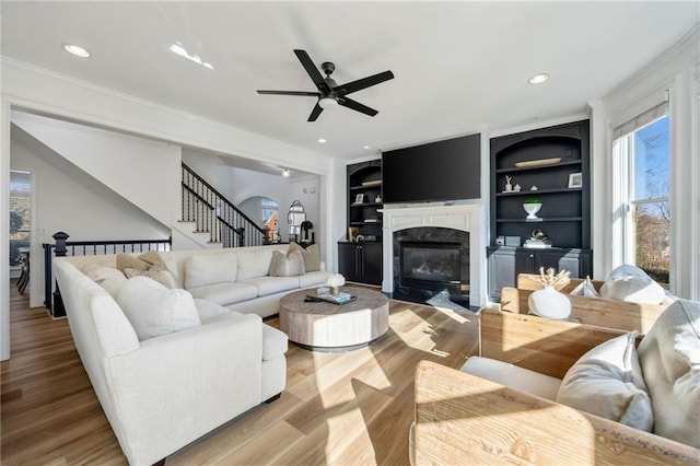 kitchen with stainless steel appliances, arched walkways, a peninsula, a breakfast bar area, and light wood-style floors
