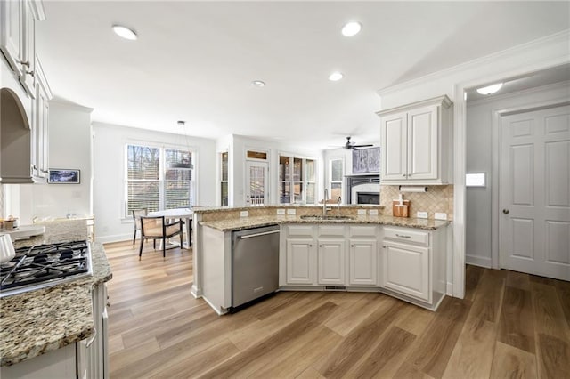 kitchen with stainless steel appliances, a sink, a peninsula, a ceiling fan, and white cabinets