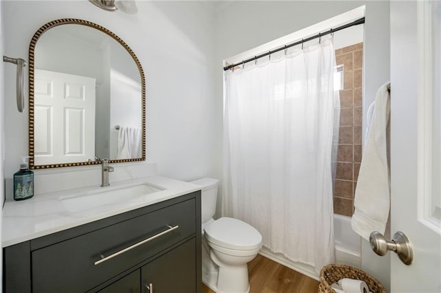 full bath featuring toilet, wood finished floors, vanity, and shower / bath combination with curtain