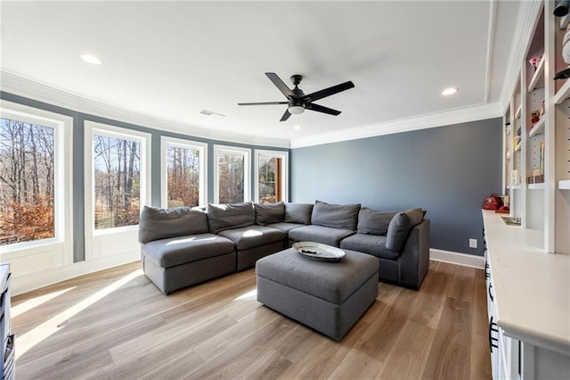 living room with ornamental molding, healthy amount of natural light, a ceiling fan, light wood-type flooring, and recessed lighting