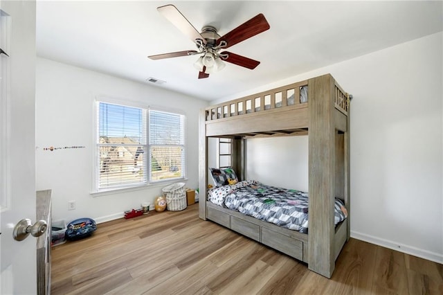 bedroom with wood finished floors, baseboards, and a ceiling fan