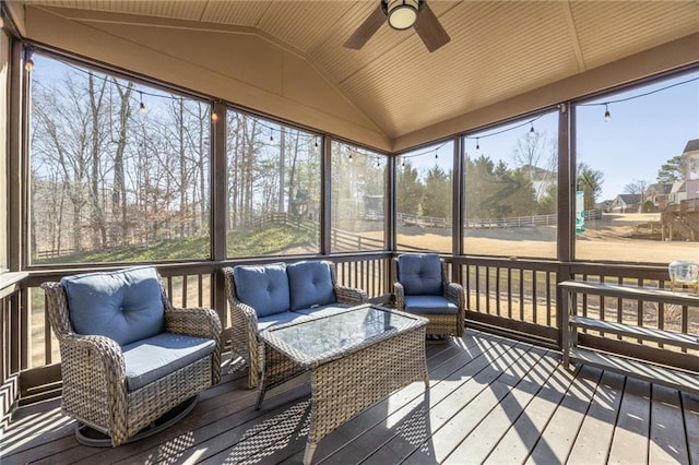 sunroom with lofted ceiling, a ceiling fan, an outdoor hangout area, and healthy amount of natural light