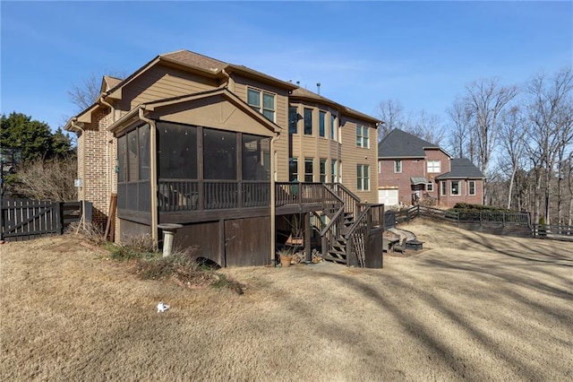 back of property featuring a sunroom, stairs, and a deck