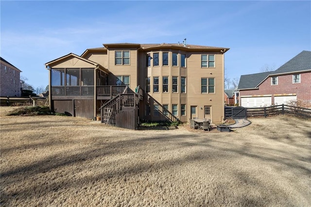 back of property featuring stairs, a sunroom, fence, an outdoor fire pit, and a wooden deck