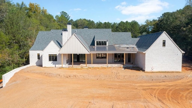 615 Hickory Flt, Milton, GA 30004 - view of front facade featuring a chimney, board and batten siding, a patio, and dirt driveway