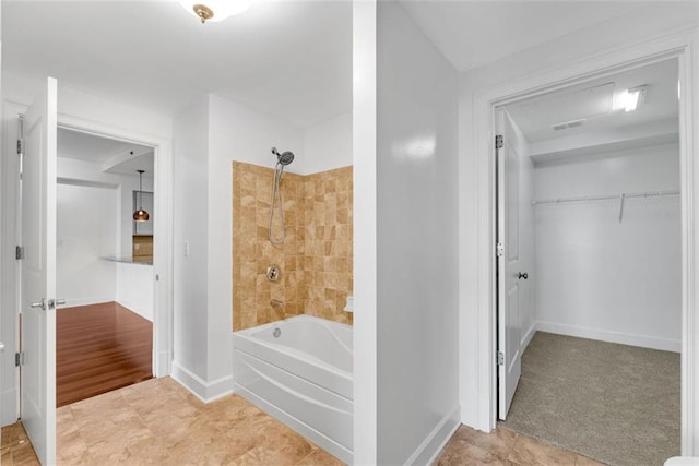 bathroom featuring tile patterned flooring and tiled shower / bath