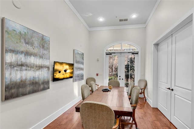 dining space featuring hardwood / wood-style flooring, french doors, and ornamental molding