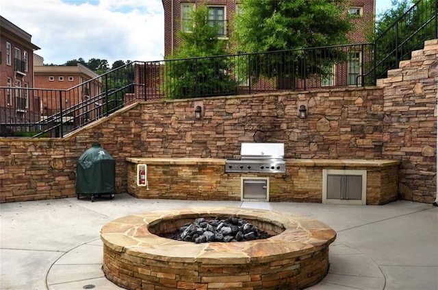 view of patio / terrace featuring a grill, an outdoor kitchen, and a fire pit