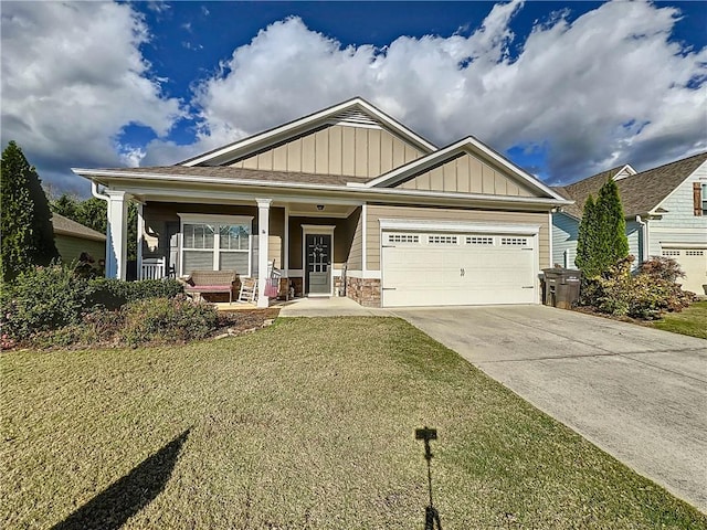 craftsman house with covered porch, a garage, and a front lawn