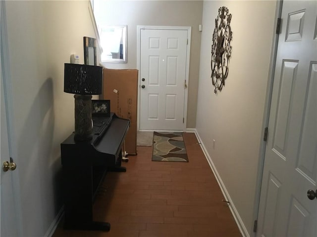 doorway to outside featuring baseboards and wood finished floors