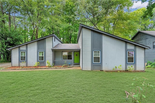 mid-century modern home with board and batten siding, a front yard, and covered porch