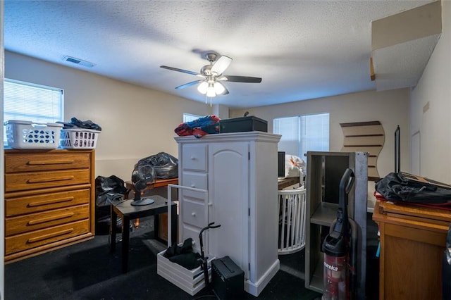 home office with a textured ceiling and ceiling fan