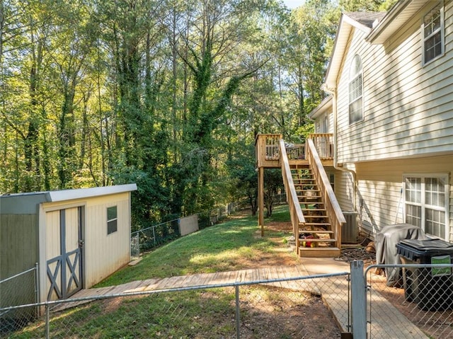 view of yard with a storage shed, a wooden deck, and central AC unit