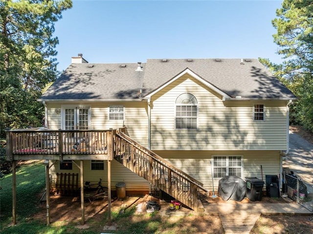 rear view of property featuring a wooden deck and a patio area