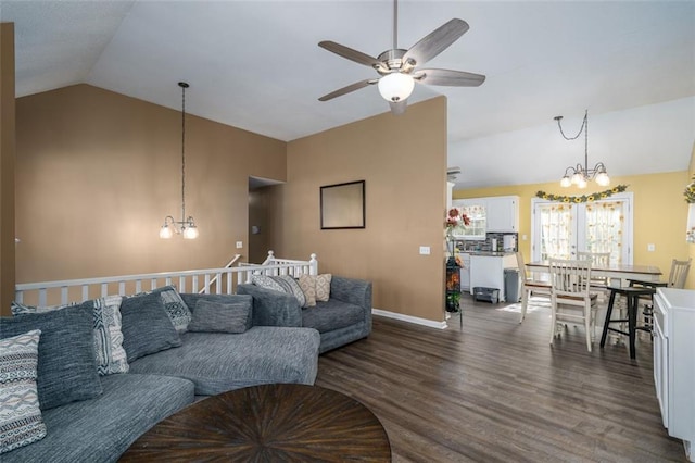 living room featuring lofted ceiling, dark wood-type flooring, and ceiling fan with notable chandelier