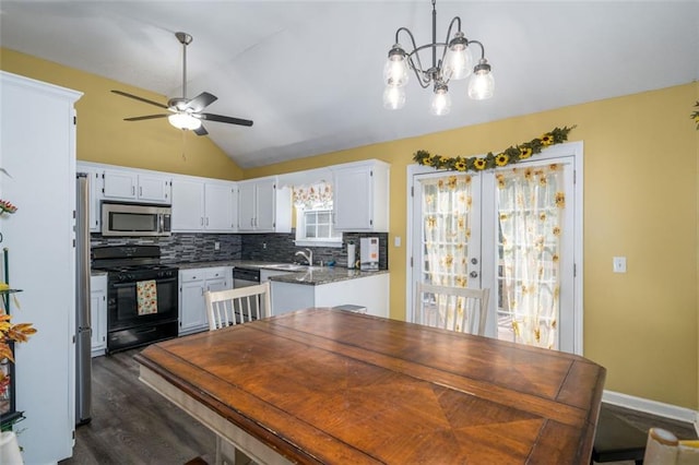 kitchen featuring stainless steel appliances, vaulted ceiling, pendant lighting, white cabinets, and dark hardwood / wood-style flooring