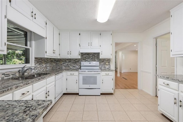 kitchen with stone countertops, white cabinetry, light tile patterned flooring, and white appliances