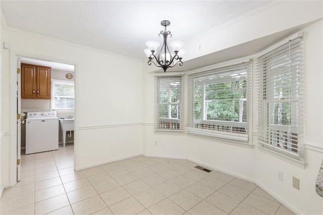 unfurnished dining area with a notable chandelier, washer / dryer, ornamental molding, and light tile patterned floors