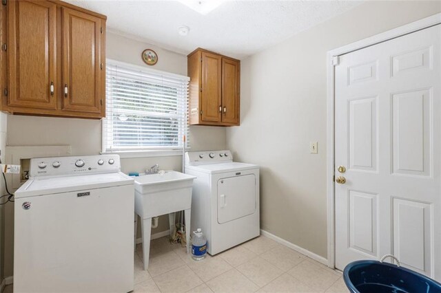 laundry room featuring washer and dryer and cabinets