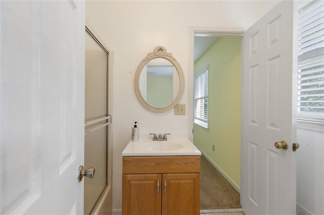 bathroom featuring vanity, tile patterned floors, a wealth of natural light, and bath / shower combo with glass door