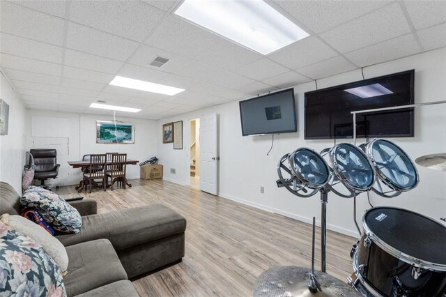 living room with a drop ceiling and light hardwood / wood-style floors