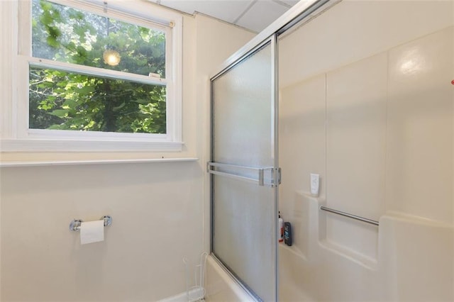 bathroom featuring shower / bath combination with glass door and a wealth of natural light