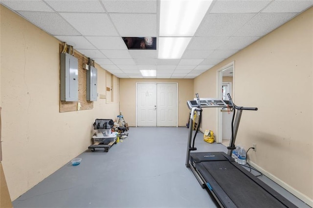 workout room featuring electric panel and a drop ceiling