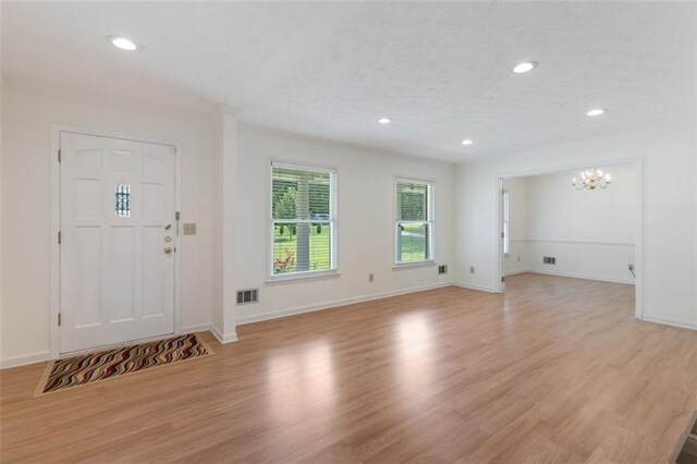 foyer featuring light hardwood / wood-style floors and an inviting chandelier