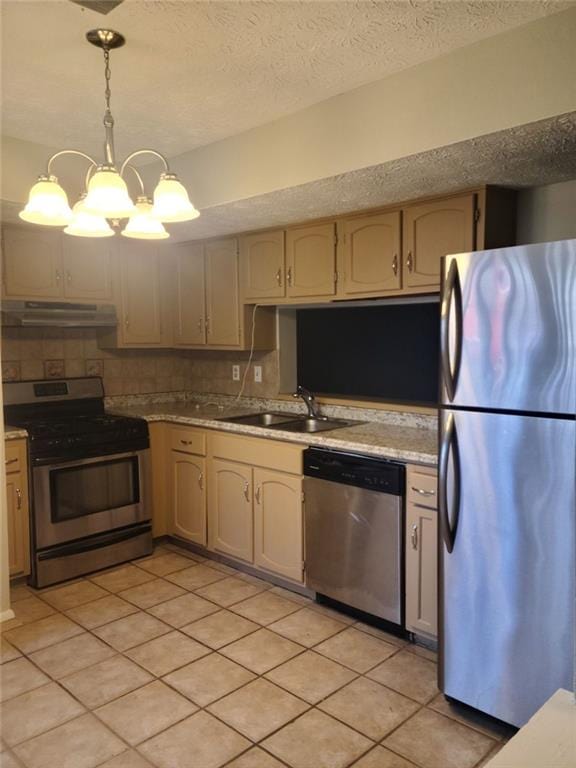 kitchen featuring pendant lighting, sink, stainless steel appliances, a textured ceiling, and decorative backsplash