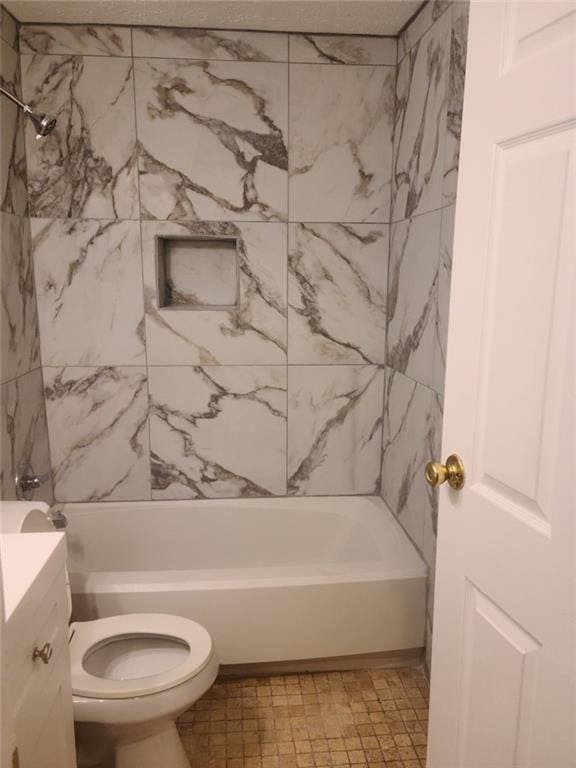 full bathroom featuring vanity, tiled shower / bath, and toilet