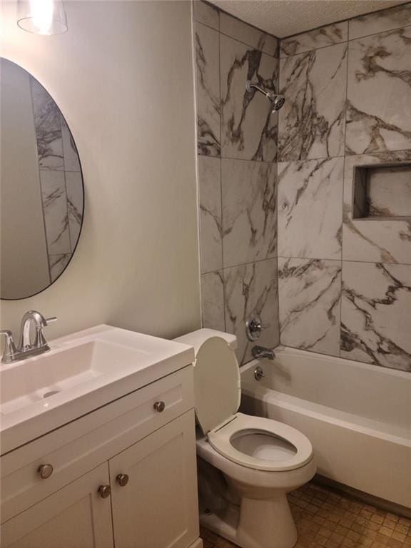 full bathroom with vanity, a textured ceiling, toilet, and tiled shower / bath