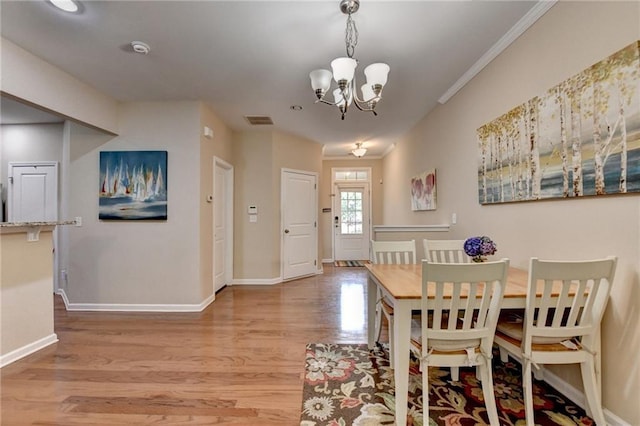 4165 Hammond Bridge Dr, Suwanee, GA 30024 - dining space featuring wood finished floors, a chandelier, and crown molding