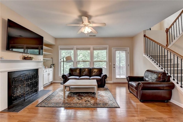 4165 Hammond Bridge Dr, Suwanee, GA 30024 - living area with a ceiling fan, a fireplace, stairway, and light wood-type flooring