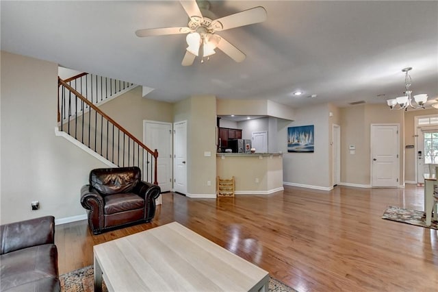 4165 Hammond Bridge Dr, Suwanee, GA 30024 - living room with wood finished floors, a chandelier, stairs, ceiling fan, and recessed lighting
