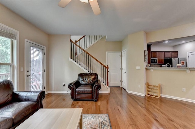4165 Hammond Bridge Dr, Suwanee, GA 30024 - living room featuring light wood-style flooring, stairway, a ceiling fan, and recessed lighting