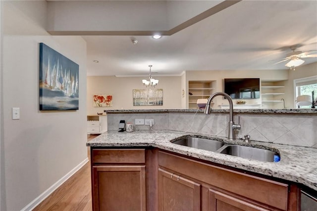4165 Hammond Bridge Dr, Suwanee, GA 30024 - kitchen featuring decorative backsplash, light wood-style flooring, light stone counters, a chandelier, and brown cabinets
