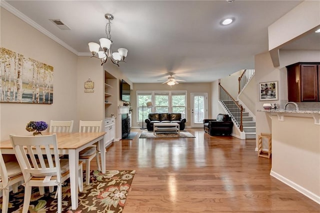 4165 Hammond Bridge Dr, Suwanee, GA 30024 - dining space featuring light wood-type flooring, a ceiling fan, stairs, a chandelier, and ornamental molding
