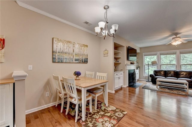 4165 Hammond Bridge Dr, Suwanee, GA 30024 - dining room with light wood finished floors, a fireplace with flush hearth, a chandelier, crown molding, and a ceiling fan