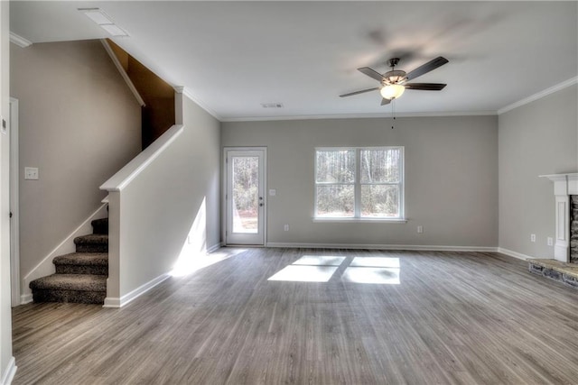 unfurnished living room with a fireplace, light wood-type flooring, ceiling fan, and ornamental molding