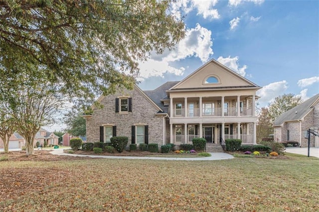 greek revival inspired property featuring a porch and a front lawn