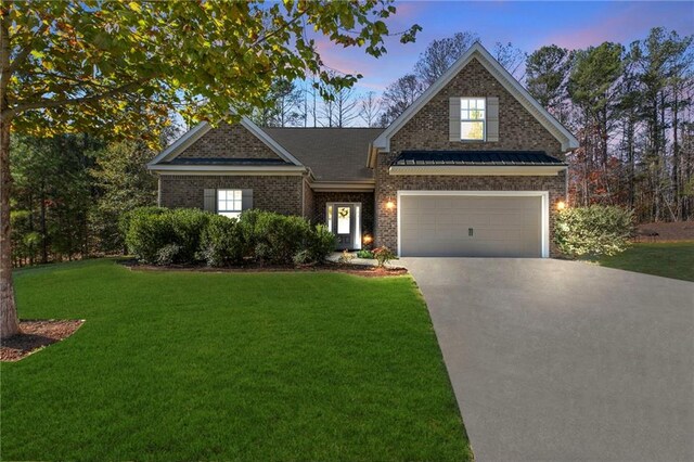 view of front of home featuring a lawn and a garage