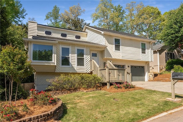 view of front of property featuring an attached garage, driveway, and a front lawn