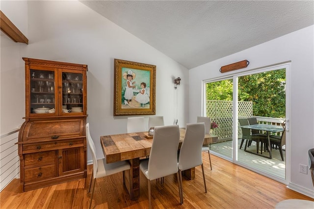 dining room featuring vaulted ceiling and light wood finished floors