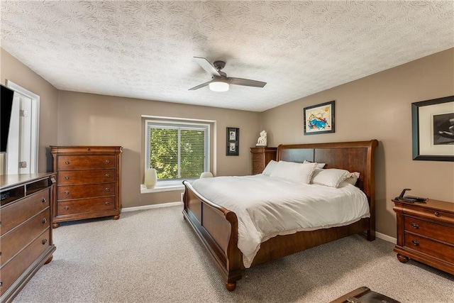 bedroom with light carpet, baseboards, a textured ceiling, and ceiling fan