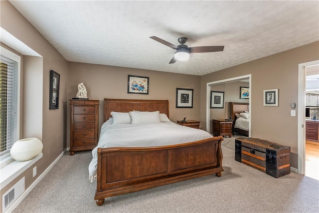 bedroom featuring carpet flooring, a textured ceiling, baseboards, a ceiling fan, and a closet