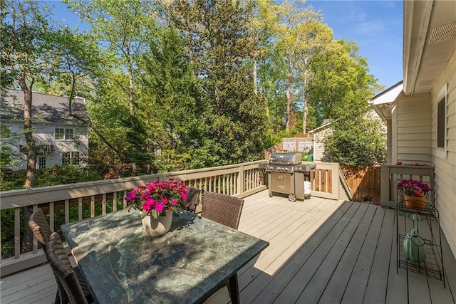 wooden terrace with grilling area and outdoor dining area