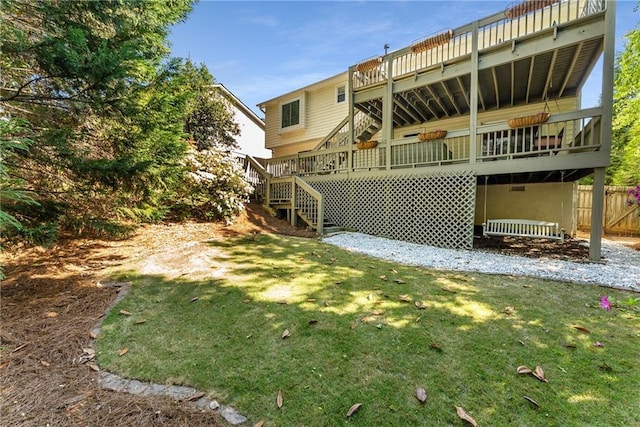 rear view of house with stairway, fence, and a yard