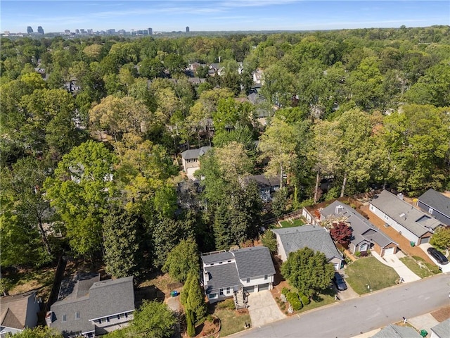 drone / aerial view featuring a residential view and a wooded view