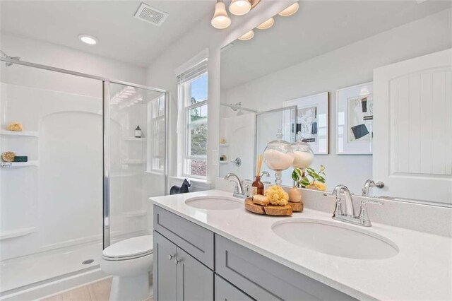 bathroom featuring walk in shower, vanity, and toilet